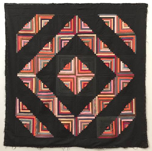 Quilt Amish quilt made up of log cabins blocks arranged in a square pattern, bright oranges on half of each block and black on the other