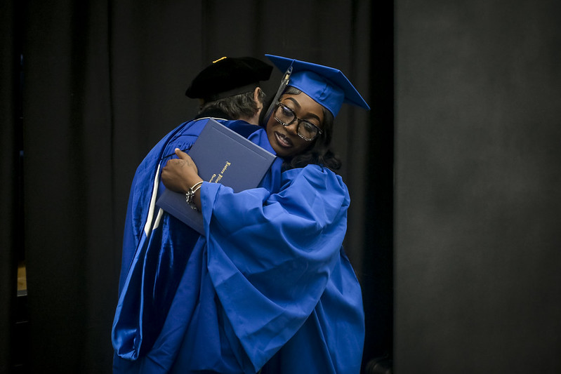 graduate hugging faculty