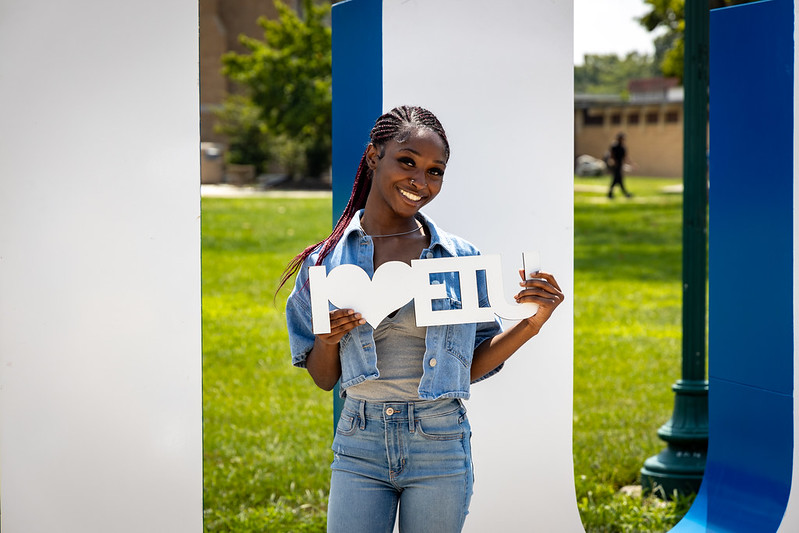 student in front of EIU letters