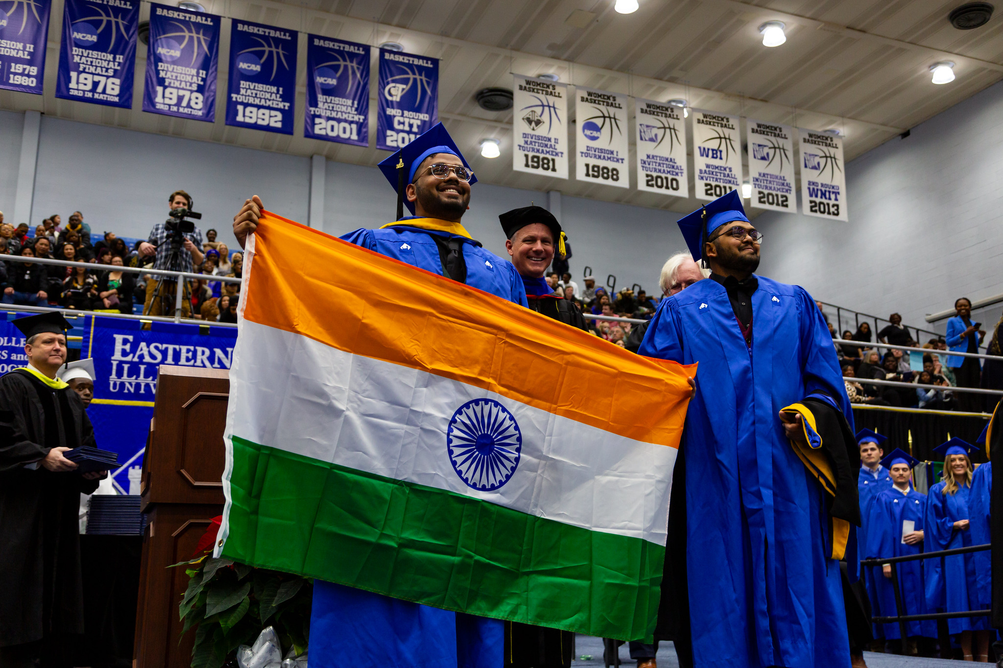 student graduating, holding india flag