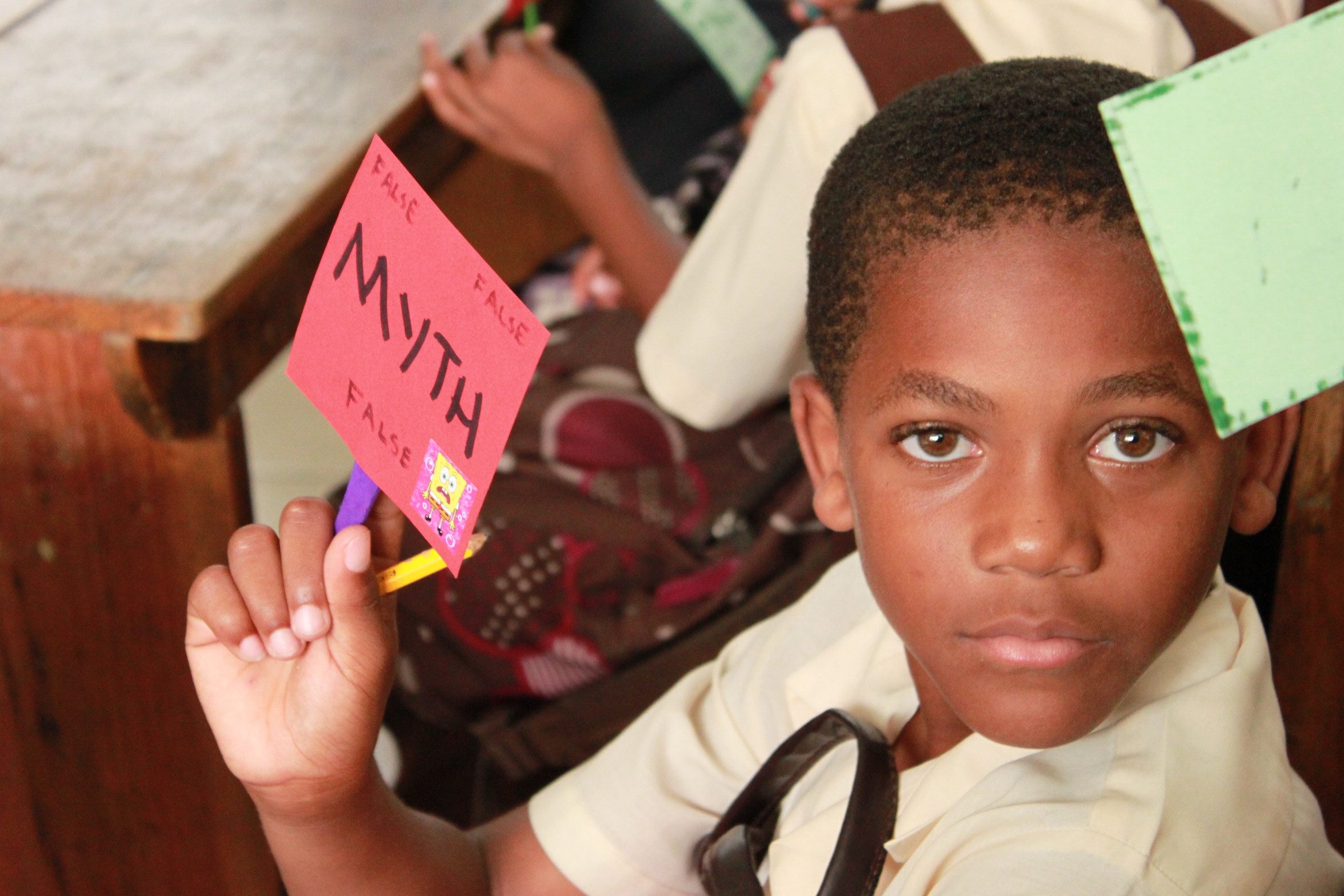 boy holding sign that says myth