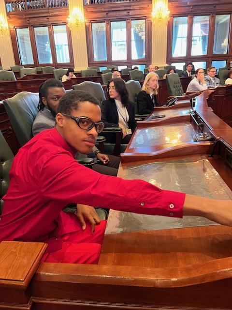 man in red shirt inside legislative chambers
