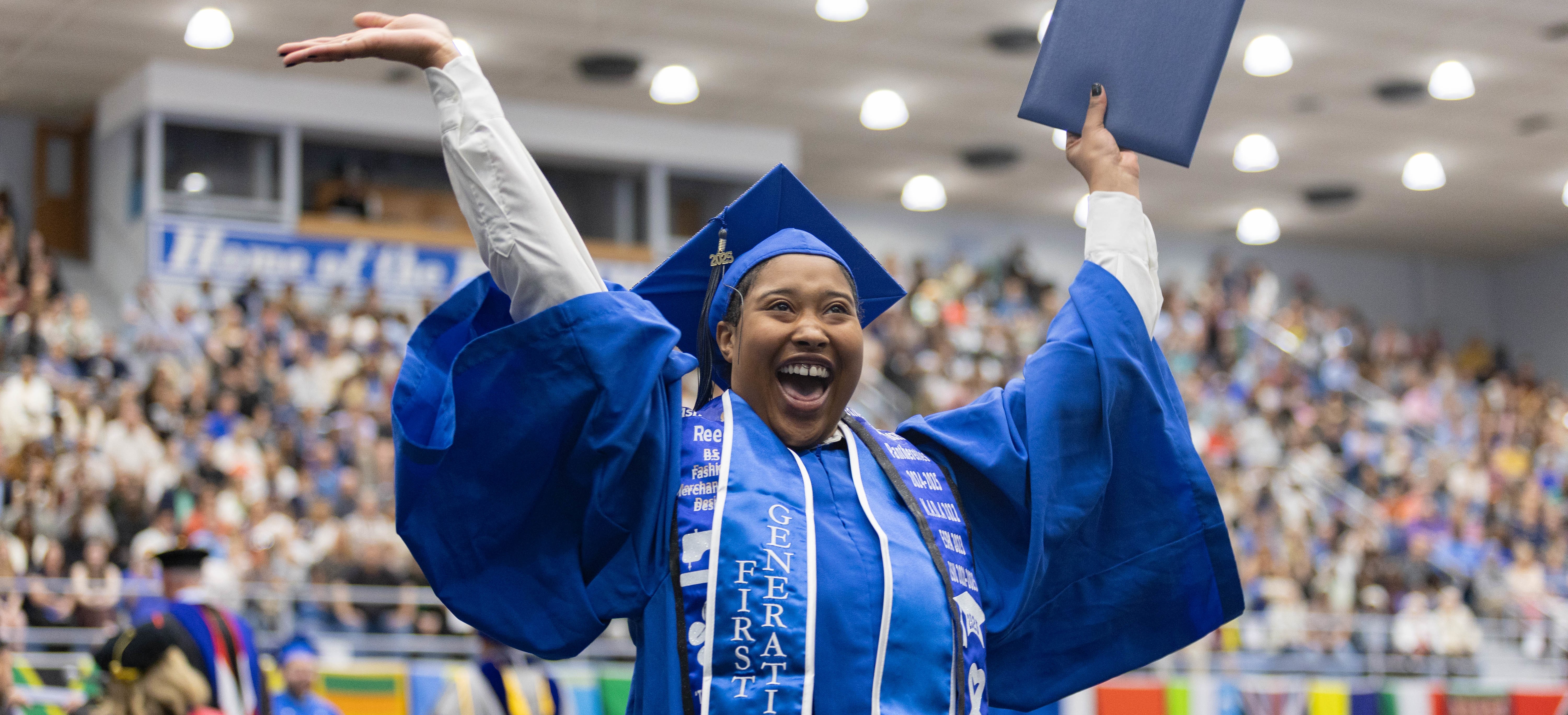 A student celebrating after graduating from EIU