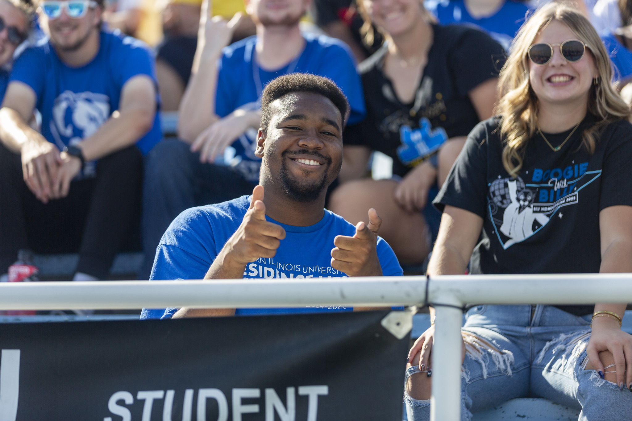 Fan in the stands pointing at the camera