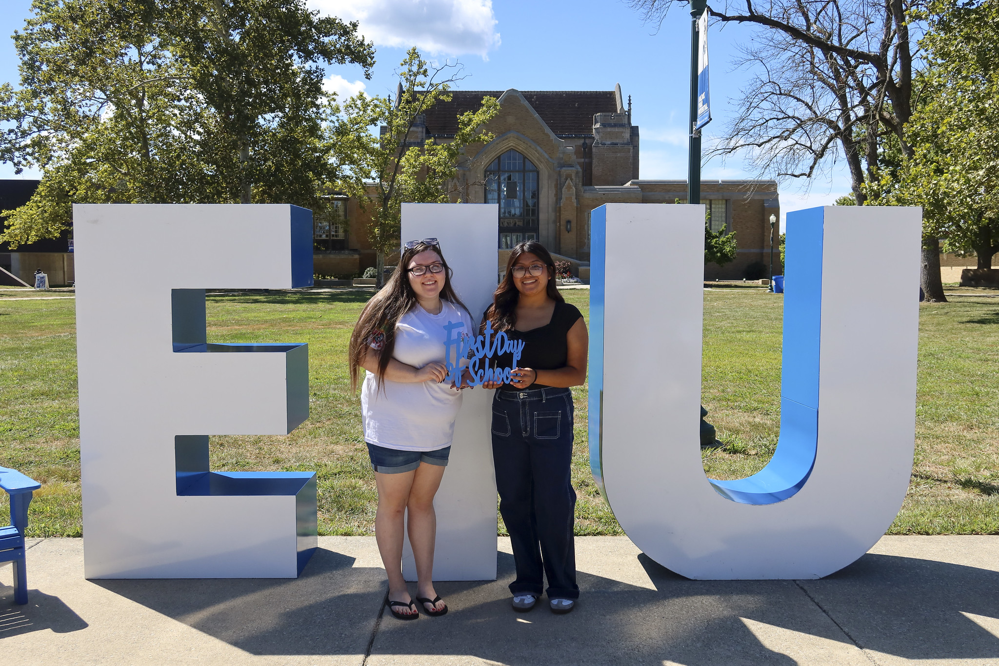 two female students posing in front of large E I U letters
