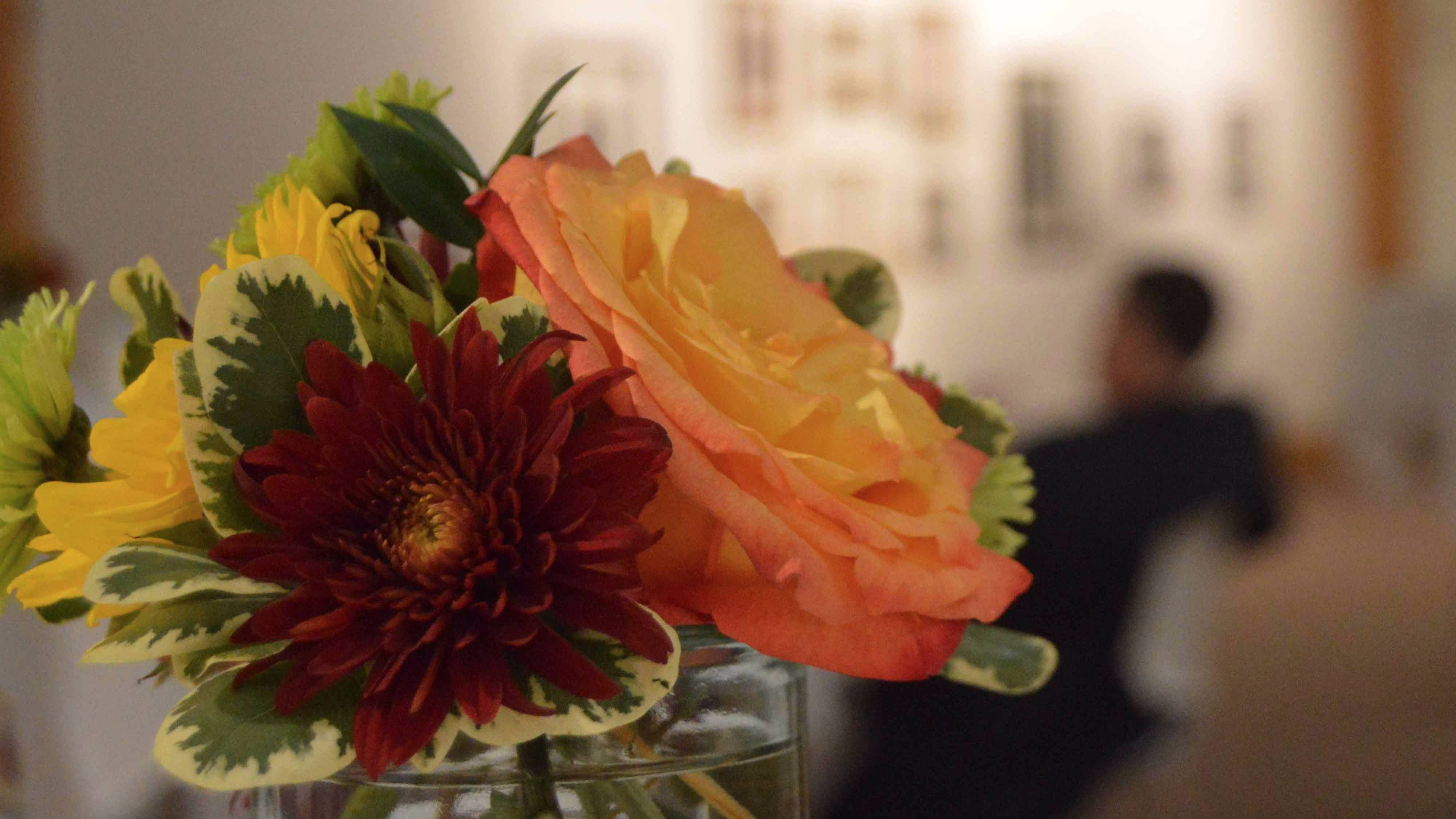 Vase of red, yellow, orange, and green flowers at the Degas Reception.