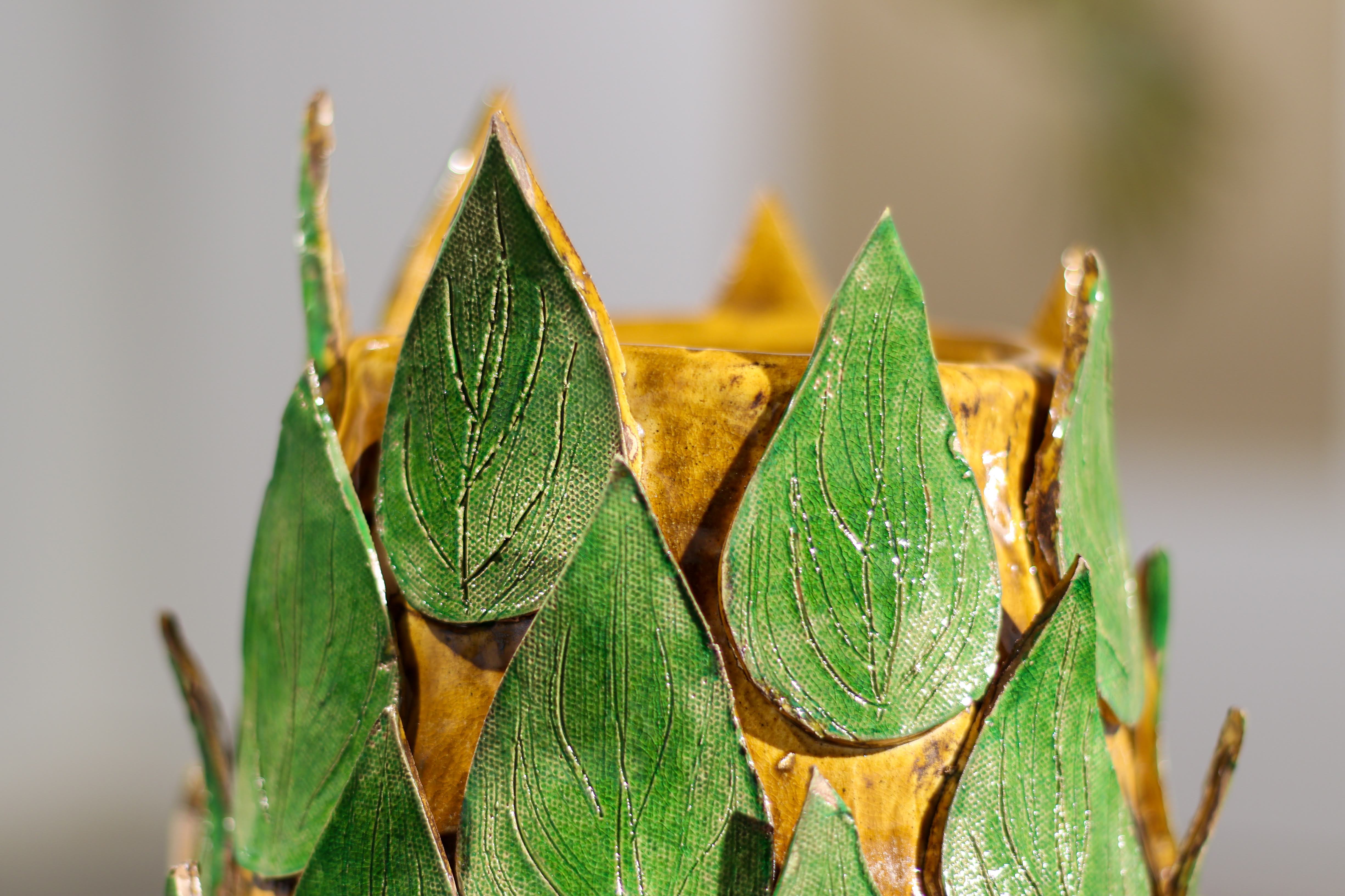 Yellow ceramic sculpture covered with green ceramic leaves from the 2021 Undergraduate Art Exhibition 